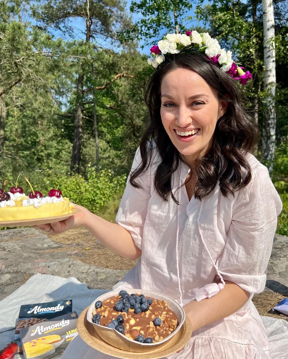 Creator in a flower crown at a picnic with an Almondy cake