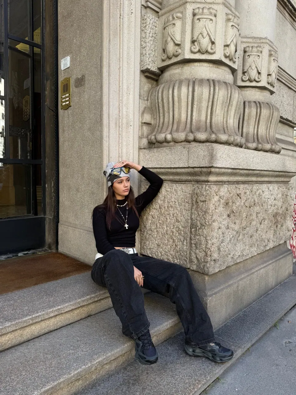 Creator wearing a black outfit outside a stone building