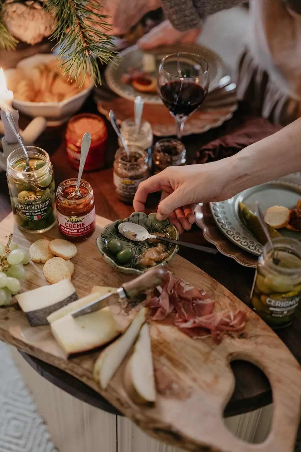 Hand reaching for a Zeta charcuterie board